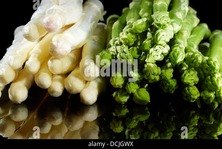 Trauben von weißem und grünem Spargel Gemüse in Schwarz Reflektierende Rückseite Stockfoto