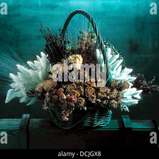 Korb mit getrockneten Blumen in einem blauen Ambiente. Stockfoto