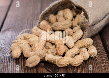 Erdnüsse in kleinen meschotschek auf hölzernen Hintergrund Stockfoto