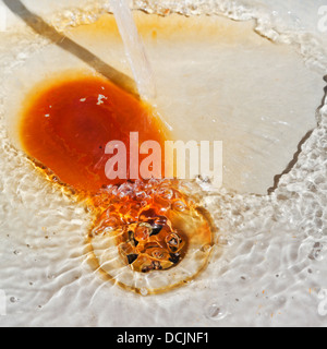 Wasser im rostigen Metall Becken entleeren Stockfoto