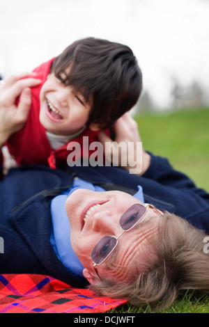 Vater mit behinderten Sohn auf dem Rasen im Park spielen Stockfoto