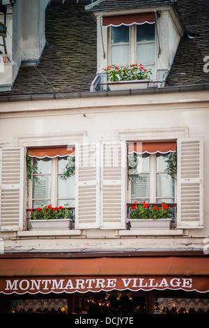 Home Fenster und Fensterläden über einem touristischen Geschäft im Dorf Montmartre, Paris Frankreich Stockfoto