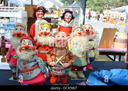 eine Sammlung von Vintage Snow White, der Prinz und die sieben Zwerge-Puppen werden auf einem Tisch Verkauf auf einem Flohmarkt angezeigt Stockfoto