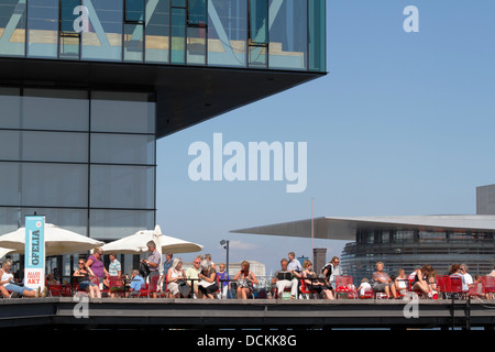 Das Royal Danish Playhouse mit Hafenrestaurant Ofelia im Hafen von Kopenhagen. Das Königliche Dänische Opernhaus auf der gegenüberliegenden Seite des Hafenkanals. Stockfoto