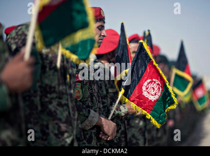 Afghan National Army stehen in Formation mit Flaggen während der Nationalhymne bei einem Feierlichkeiten afghanischen Unabhängigkeitstag 19. August 2013 in Camp Shorabak, Provinz Helmand, Afghanistan. Stockfoto