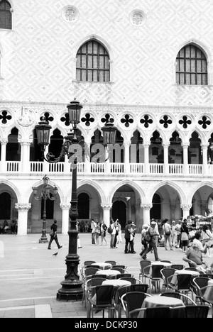 Schwarz / weiß Foto von Café-Tischen in Venedig mit dem Palazzo Ducale (Dogenpalast) hinter, Venedig, Italien Stockfoto