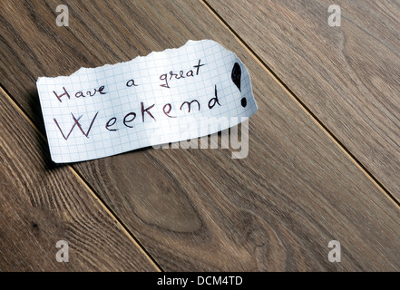 Habt ein schönes Wochenende - Hand schreiben von Text auf einem Blatt Papier auf Holz Hintergrund mit Platz für text Stockfoto