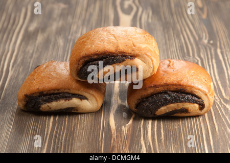Brötchen mit Mohn auf einem Holztisch Stockfoto