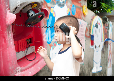 Glückliche Kinder hören das Telefon Spielzeug Stockfoto