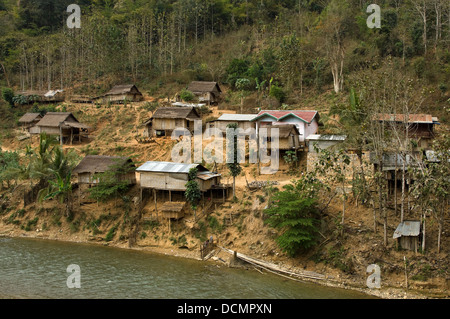 Horizontale Ansicht der traditionellen gestelzt Holzhütten und Häuser klammerte sich an den Ufern des Nam Song Flusses in der Nähe von Vang Vieng Stockfoto