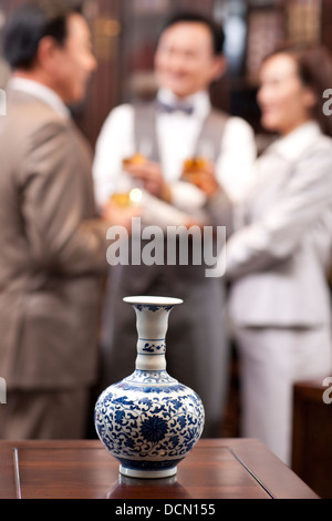 Nahaufnahme von kostbare Vase mit Geschäftsleuten im Hintergrund Stockfoto