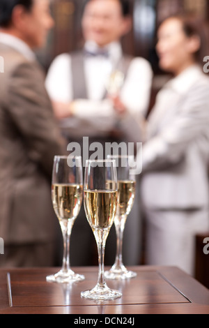 Nahaufnahme von Champagner mit Geschäftsleuten im Hintergrund Stockfoto