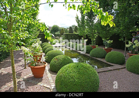 Der Teich und Topiary im Upper Rill Garden in Wollerton Old Hall Gardens Garten Wollerton Market Drayton Shropshire England Großbritannien Stockfoto