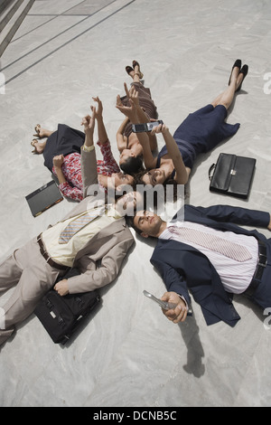 Geschäftsleute, die auf dem Boden liegend Stockfoto