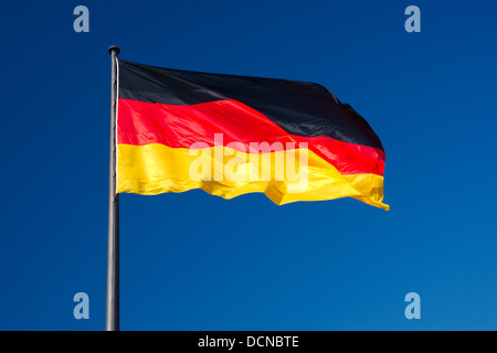 Nationalflagge von Deutschland gegen den blauen Himmel als Hintergrund Stockfoto