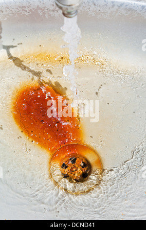 Wasserstrahl und Trockenlegung im rostigen Metall Becken Stockfoto