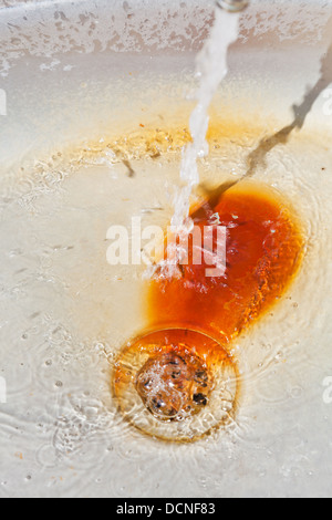 fließendes Wasser aus Wasserhahn im rostigen Metall Becken Stockfoto