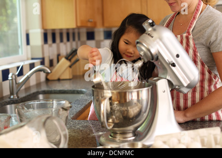 Junge Mädchen, die Mutter in der Küche Backen helfen Stockfoto