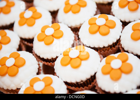 leckere Schokolade Cupcakes mit orangen Blüten an der Spitze Stockfoto