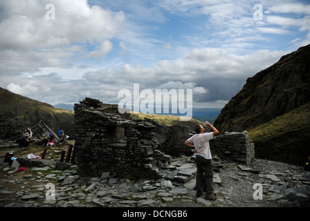 Wanderer für Rest stop und Wasser in einem stillgelegten Schiefer mir auf der Seite des alten Mannes Coniston, The Lake District National Park, UK Stockfoto