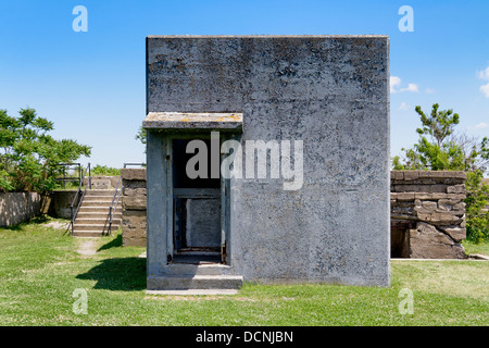 Boston, Massachusetts: Ein weißer Beton utility Gebäude steht steif und kalt vor blauem Himmel am Fort Warren (Georges Insel). Stockfoto