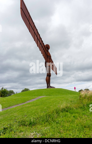 Ein Volk am Fuße des massiven Engels der Norden Skulptur von Anthony Gormley in Gateshead mit Skala Stockfoto