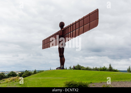 Eine Gruppe von Menschen am Fuße des massiven Engel des Nordens Skulptur von Anthony Gormley in Gateshead mit Skala Stockfoto