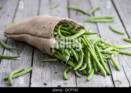 Einige grüne Bohnen auf hölzernen Hintergrund Stockfoto