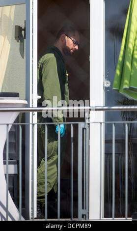 Heidelberg, Deutschland. 21. August 2013. Ein Polizist sichert Beweise auf dem Balkon an einem Tatort in Dossenheim bei Heidelberg, 21. August 2013. Am 20. August 2013 ein Mann erschossen zwei Männer, fünf Menschen verletzt und nahm dann sein eigenes Leben während Inhaber treffen. Foto: UWE ANSPACH/Dpa/Alamy Live News Stockfoto