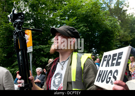 Website der Cuadrilla bohren. Demonstration gegen Fracking. Ein Demonstrant mit Videokamera und ein Schild mit der Aufschrift Free Hugs Stockfoto