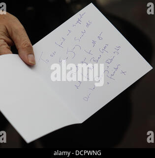 Ein Trauernder hält eine Karte von Barry und Robin Gibb der Beerdigung von Sir Jimmy Savile gehalten an der Leeds Kathedrale in Leeds, England - 09.11.11 Stockfoto