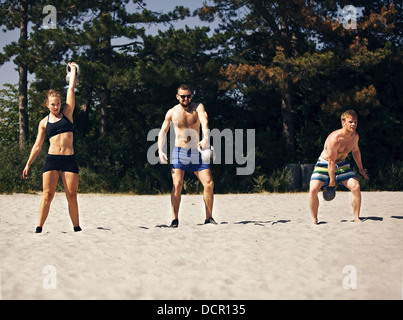 Drei Leute, die Crossfit Training am Strand Stockfoto