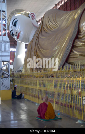Ein buddhistischer Mönch betet vor einer Buddhastatue in Chauk Htat Gyi Pagode in Rangun Stockfoto