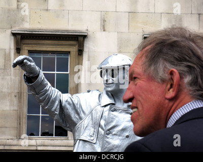 Straßenkünstler Straßenmusiker in Silber gekleidet unterhält eine Menschenmenge am Trafalgar Square in London Stockfoto