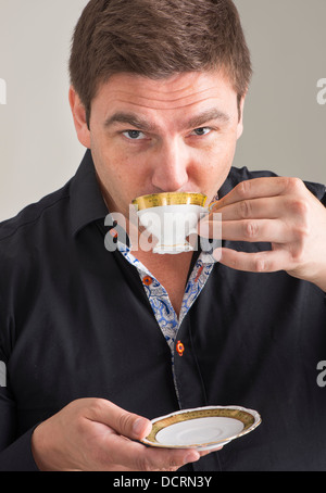 Geschäftsmann in schwarzes aufgeknöpft Hemd mit einer Tasse Kaffee entspannen Stockfoto