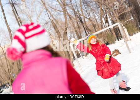 Kinder im Winter Park spielen Schneebälle Stockfoto