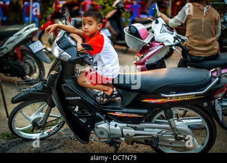 7. Januar 2013 - Kampong Saom, Sihanoukville, Kambodscha - 7. Januar 2013 - auf zwei Rädern angesprochen werden die Kinder in Kambodscha wie jeder andere hier Ihr Motorrad in der Stadt Sihanoukville verschoben... Geschichte-Zusammenfassung: Inmitten der fieberhaften Tempo der Phnom PenhÃ• Straßen der Stadt, ein "Arbeitspferd" der Transport von Personen und Gütern entsteht: Fahrräder, Motorräder, Roller, Mopeds, Motodups und Tuk Tuks durchstreifen anstelle von Pkw und LKW. Fast 90 Prozent der Fahrzeuge roaming der kambodschanischen Hauptstadt von fast 2,3 Millionen Menschen wählen diese für unterwegs. Staus und Umwelt profitieren von der smal Stockfoto