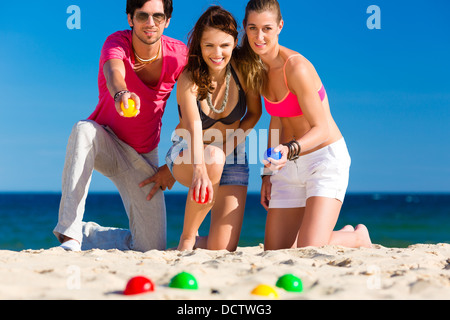 Gruppe von Jugendlichen spielen Boule am Strand im Sand im Freien im Sommer Stockfoto