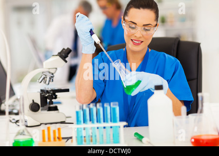intelligente weibliche Laborantin Umgang mit Flüssigkeit im Labor Stockfoto