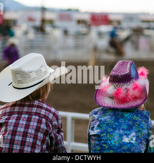 Junge & Mädchen gehockt Corral Zaun beobachten das Chaffee County Rodeo Stockfoto