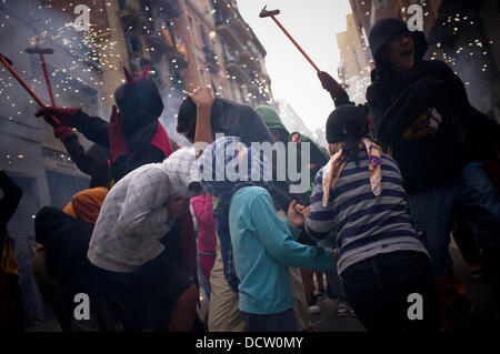 Barcelona, Spanien 21. August 2013. Kinder geschützt Köpfe des Teufels beschossen. Im Rahmen der Feierlichkeiten von Gracia Viertel hat ein Kinder "Correfoc" in den Gassen dieses Teils von Barcelona statt. Correfocs sind eine alte katalanische Tradition, wo Menschen als Teufel und Licht Kleid bis Feuerwerkskörper und Fackeln. Bildnachweis: Jordi Boixareu/Alamy Live-Nachrichten Stockfoto