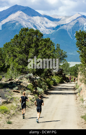 Zwei trail Läufer entlang der Midland Trail, CR304, in der Nähe von Buena Vista, Colorado. Stiftskirche Gipfeln über. Stockfoto