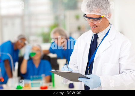 Smart senior-Wissenschaftler schreiben ärztliches Gutachten im Labor Stockfoto