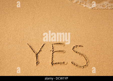 Ja - geschrieben in Sand am Meer-Strand-Textur Stockfoto