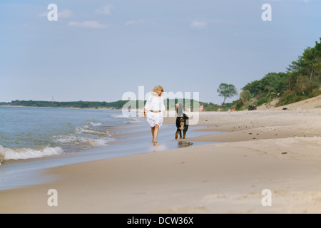 Berner Sennenhund und Frau geht in der Nähe von Meer Stockfoto