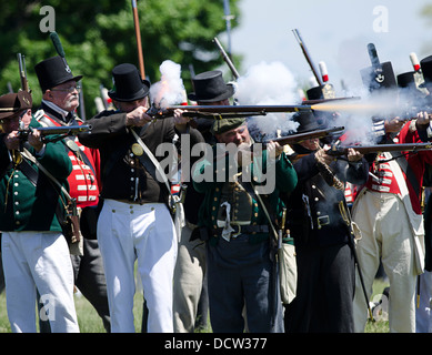Britische Soldaten feuern auf die herannahenden amerikanischen Soldaten bei einem Re Inszenierung der Schlacht von Fort George. Stockfoto
