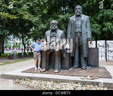 Senior Mann stehend mit Skulpturen von Karl Marx und Friedrich Engels - Marx-Engels-Forum, Mitte, Deutschland, Berlin Stockfoto