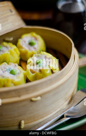 Huhn Sui Mai, ein chinesisches Gericht, in einem Bambus-Dampfer bereit, als Starter für die Mahlzeit serviert werden. Stockfoto