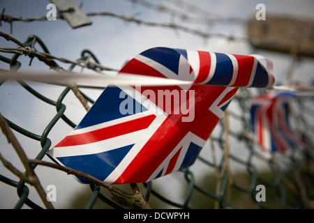 Union Jack Bunting Flagge auf einem Drahtzaun mit Stacheldraht Stockfoto