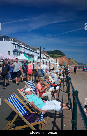 Relaxen in Liegestühlen auf der Esplanade während das Folk-Festival in Sidmouth Devon UK Stockfoto